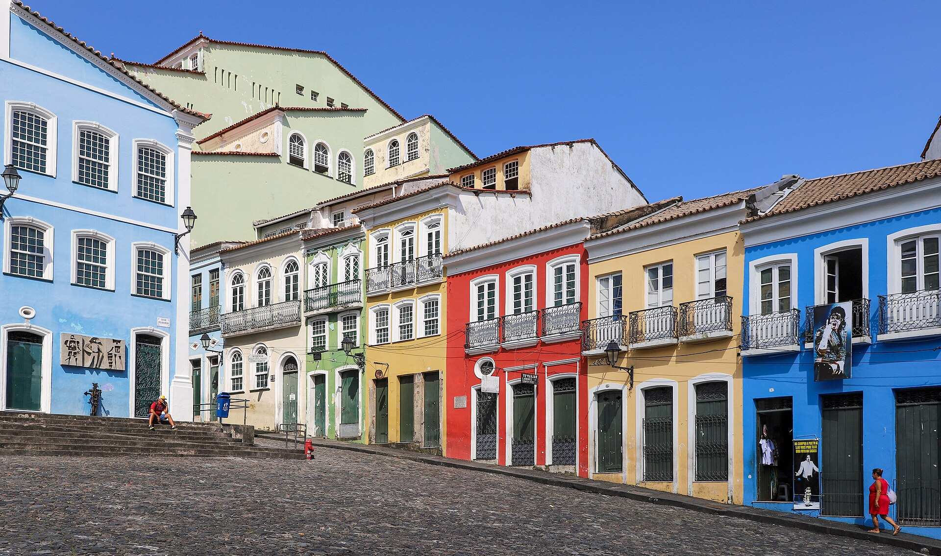 Casarões coloridos de fachadas azul, vermelha e amarela em volta do Largo do Pelourinho, em Salvador, sob céu azul