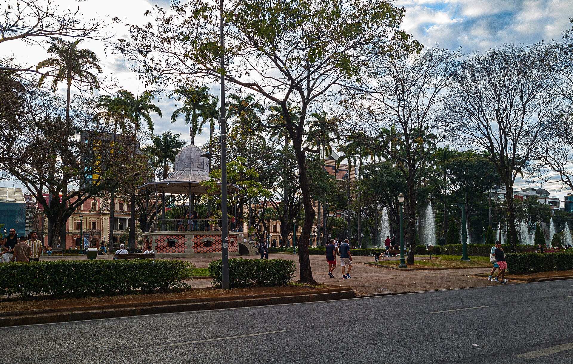Coreto, árvores e fontes da Praça da Liberdade, em Belo Horizonte, com pessoas caminhando